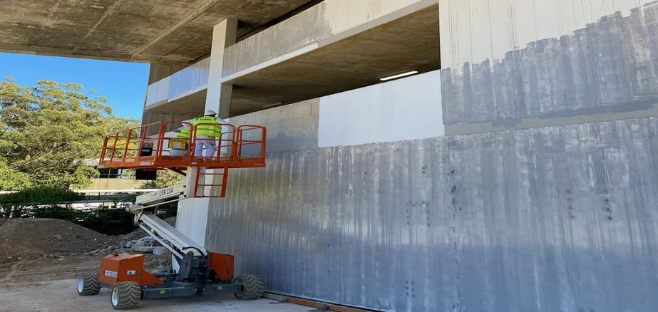 ProLux crew painting a large commercial building from an elevated work platform in Sydney